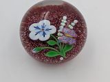 un petit objet en verre orné d'une fleur