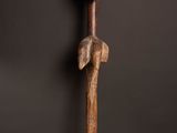 une sculpture en bois représentant une tête d'homme posée sur un socle