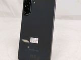 the back of a black samsung galaxy s10e phone on a white surface