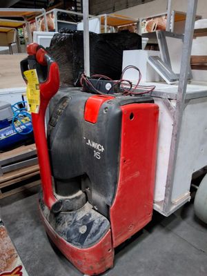 un chariot élévateur rouge et noir garé dans un entrepôt