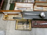 a lot of silverware in a box on the floor