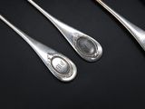 four spoons with a picture of a woman on them on a black surface