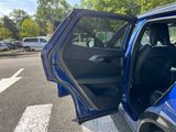 a blue car with its door open on the street