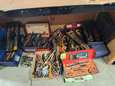de nombreux outils divers dans une boîte posée par terre