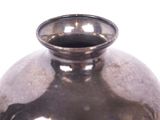 a silver vase that is sitting on a table
