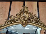 a mirror with a gold frame and a mirror hanging on the wall