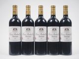 quatre bouteilles de vin sont alignées sur une surface blanche