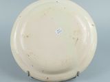 underside view of a white plate with a brown spot on the rim