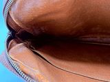 a brown purse with a zipper open on a blue background