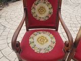 two red chairs with floral designs on them on a brick patio