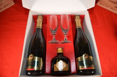 three bottles of wine and two glasses in a box