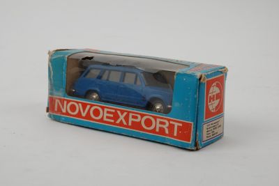 une petite voiture bleue dans une boîte posée sur une surface blanche
