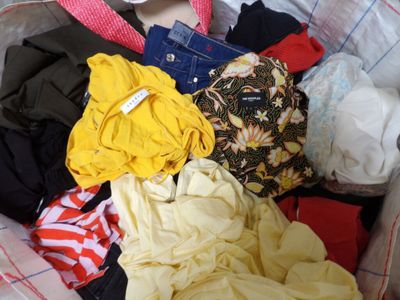 a suitcase full of clothes and a hat on the bed
