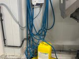 a yellow and blue device on the floor next to a blue hose