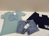 two pairs of shorts and a t - shirt are on a table