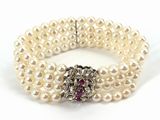 bracelet à trois rangs de perles, avec une pierre rose au centre et un fermoir en argent