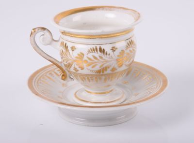 une tasse et une soucoupe sur une soucoupe sur une surface blanche