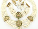 une collection de bijoux en perles et en or, comprenant un collier, des boucles d'oreilles et une broche