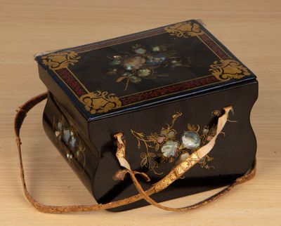 une petite boîte noire ornée d'un motif floral