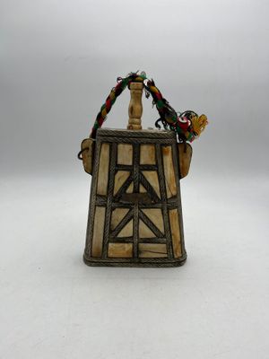a figurine of a bird sitting on top of a wooden structure