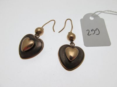 une paire de boucles d'oreilles ornées d'un cœur, posée à côté d'une étiquette de prix