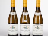 trois bouteilles de vin posées les unes à côté des autres sur une surface blanche