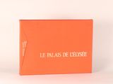 une boîte orange avec une inscription blanche, posée sur une table