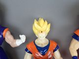 three figurines of dragon ball characters are posed in a row