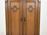 une image représentant une armoire en bois à deux portes, munie d'une poignée