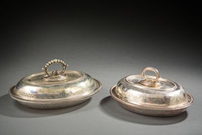 paire de plats argentés avec couvercles, posés sur un support gris