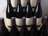 bottles of red wine sit in a wooden crate on a table