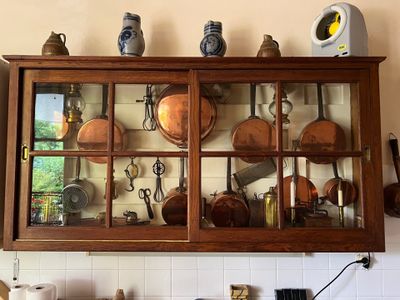 de nombreuses casseroles et poêles sur l'étagère au-dessus de l'évier de la cuisine