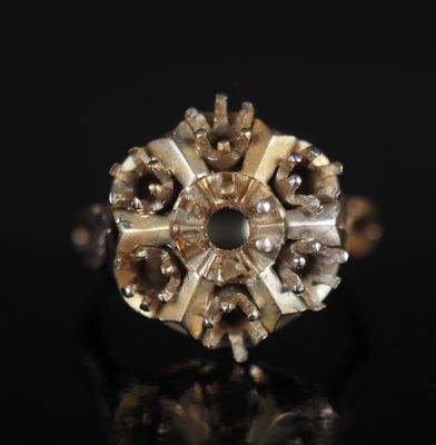 gros plan d'une bague en or et diamants sur une surface noire