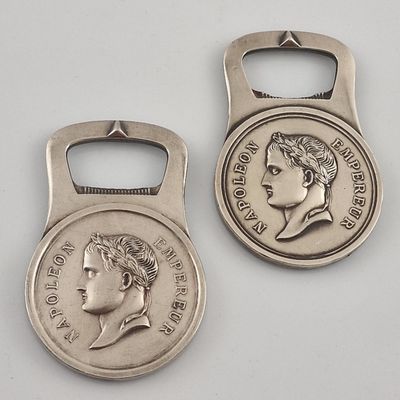 deux décapsuleurs en forme de pièces d'argent, sur lesquels est représenté le visage d'une femme