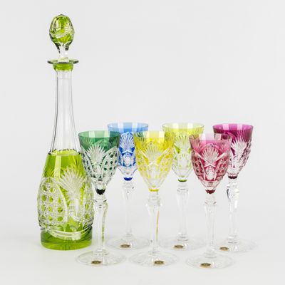 des bouteilles et des verres sont alignés en rangée sur une surface blanche