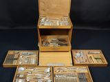 un assortiment d'argenterie dans un coffret en bois sur fond noir