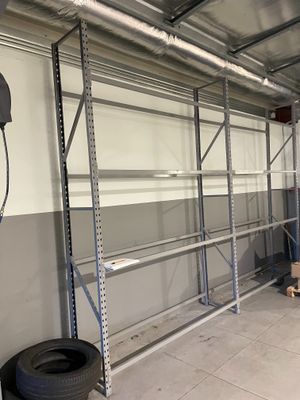un garage avec un pneu posé par terre à côté d'une étagère