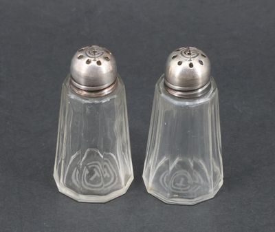 une paire de salières et poivrières posées sur une surface noire