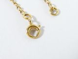 a close up of a gold chain with a clasp on a white surface