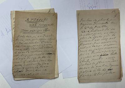 two old papers with writing on them sitting on top of a table