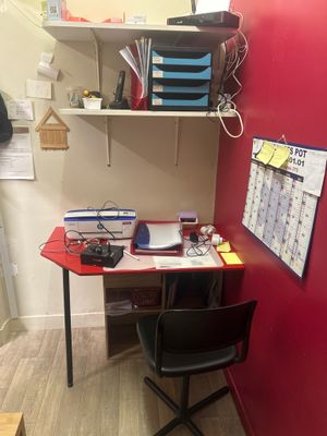 un bureau rouge avec une chaise noire devant un mur rouge