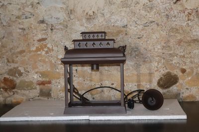 une petite lanterne posée sur une table près d'un mur de briques