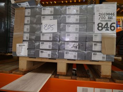 une palette remplie de cartons, placée sur une autre palette dans un entrepôt