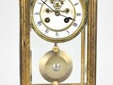 a gold clock with a glass case on top of it