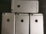 four silver iphones sitting next to each other on a table