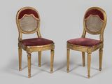 paire de chaises dorées dont les assises sont recouvertes de velours rouge