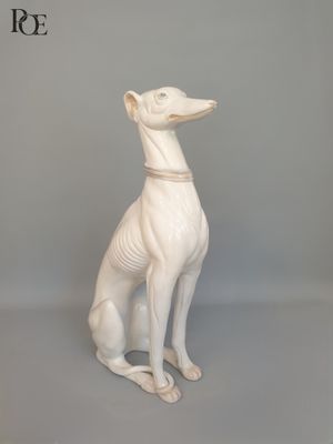 une statue blanche représentant un chien assis sur une table
