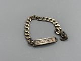 a close up of a silver bracelet with a nameplate on it