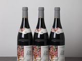 trois bouteilles de vin posées sur une table en bois