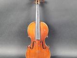 un vieux violon posé sur une table près d'un mur